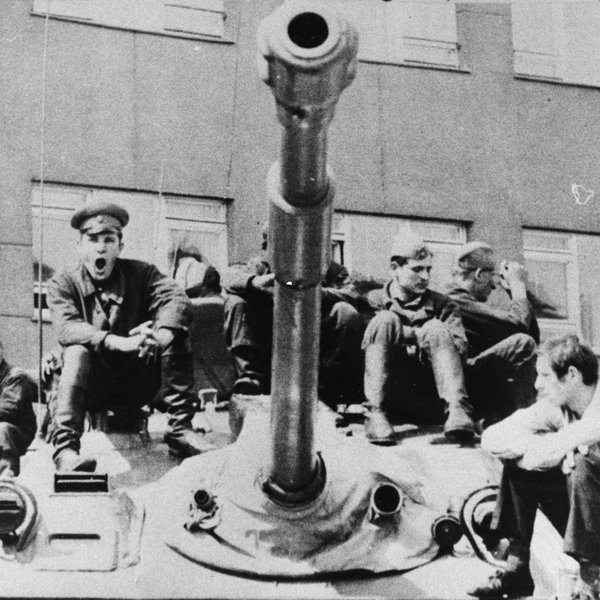 Sovětští vojáci a místní obyvatelé sedí na tanku v ulici Prahy v srpnu 1968